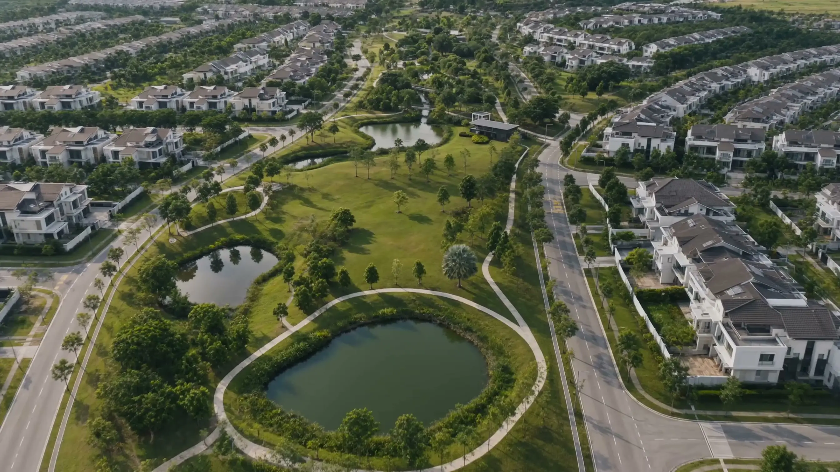Aerial view of Eco Majestic township: the central park and lake with tree-lined homes on both sides